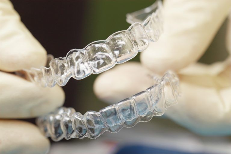 Hands Holding Transparent Aligner