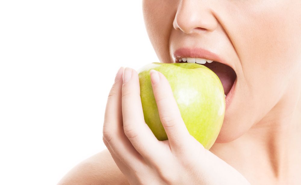 Dental Health and Your Diet - woman eating a green