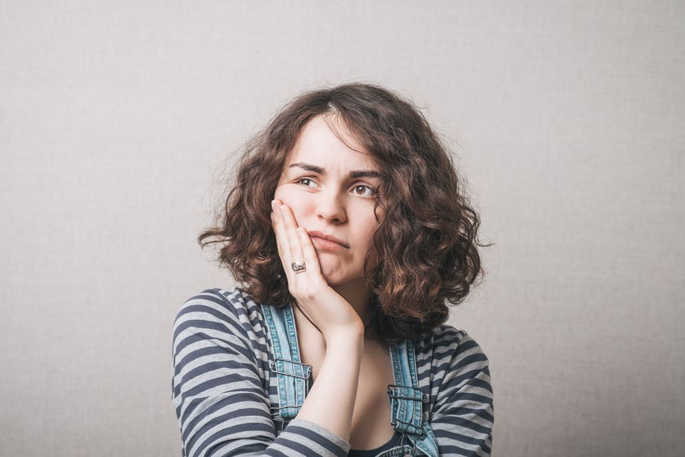 Woman toothache. Gray background unhappy